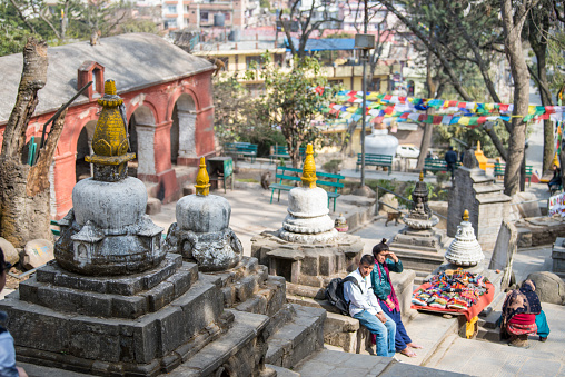 Kathmandu, Nepal- April 20,2023 : People visit the ancient stupas of Swayambhunath temple high above Kathmandu.