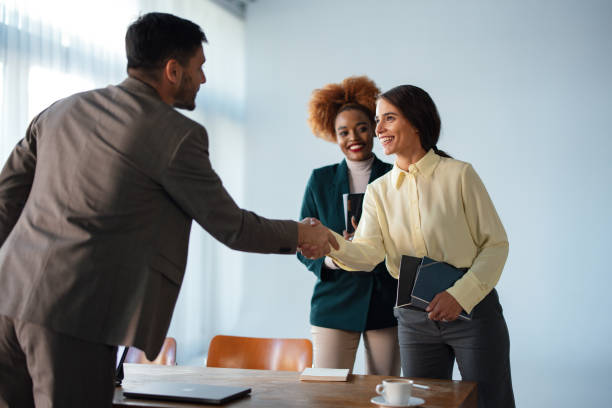 istock Group of Businesspeople Introducing and Greeting Each Other by Shaking Hands 1949596175