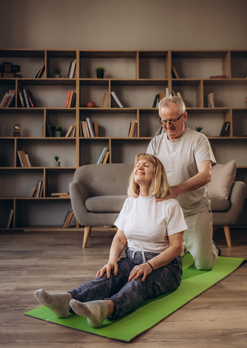 Portrait of happy senior couple performing exercise at home