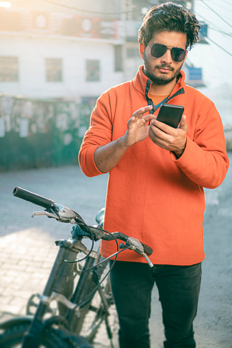 A young man uses his phone's GPS and a bicycle to easily reach any destination within a 15-minute city of Himachal Pradesh for a sustainable and eco-friendly lifestyle.