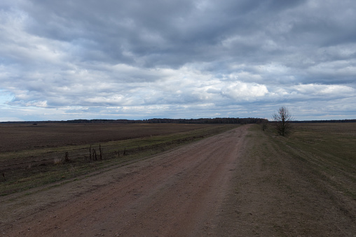 A dirt road among the fields in the evening. Autumn landscape.