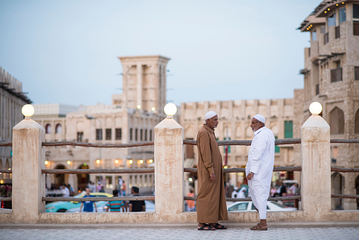 Doha, Qatar - April 22,2023: Local people in traditional attire in old bazaar market Souk Waqif.