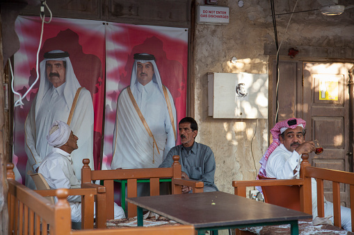 Doha, Qatar - April 22,2023: Local people in traditional attire in old bazaar market Souk Waqif.