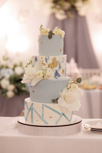 istock Three-tiered wedding cake with blue and gold accents 1949739830