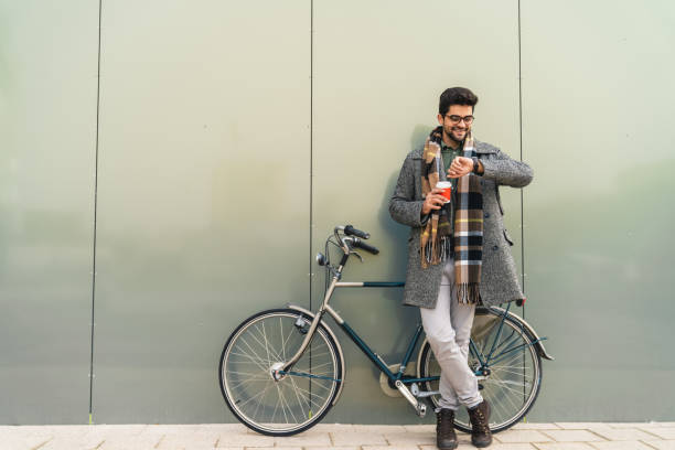 istock Handsome businessman with bike checking time while waiting for company 1949786984