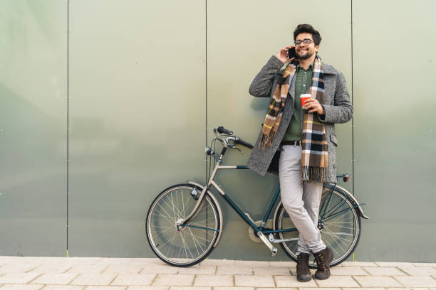 istock Shot of a businessman using his cellphone while going to work with his bicycle 1949787003