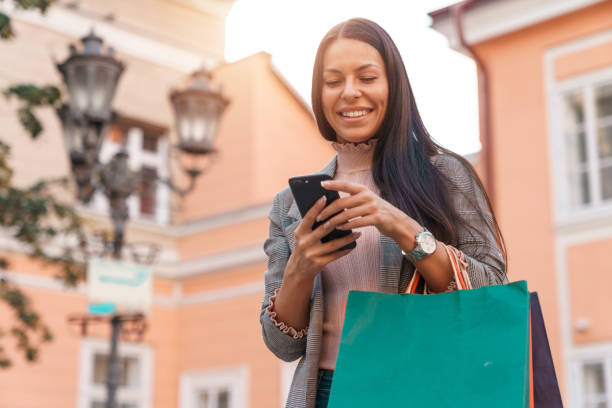 istock Attractive female smiling while texting message or checking her bank account 1949806102