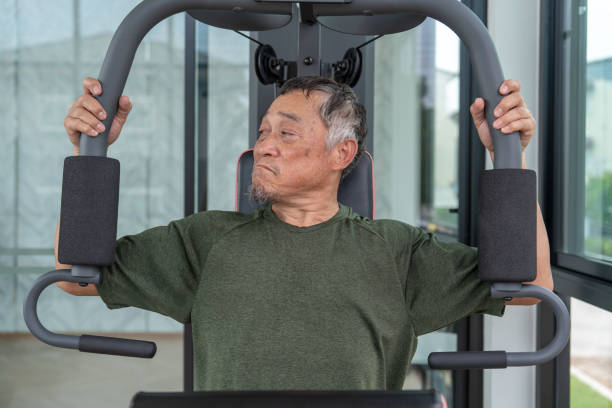 istock Elderly, Retired or Senior Asian man using pull-down machines to build muscle. 1949817371