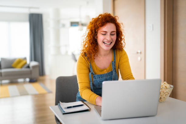 istock Smiling ginger woman sitting casually dressed in home office 1949827114