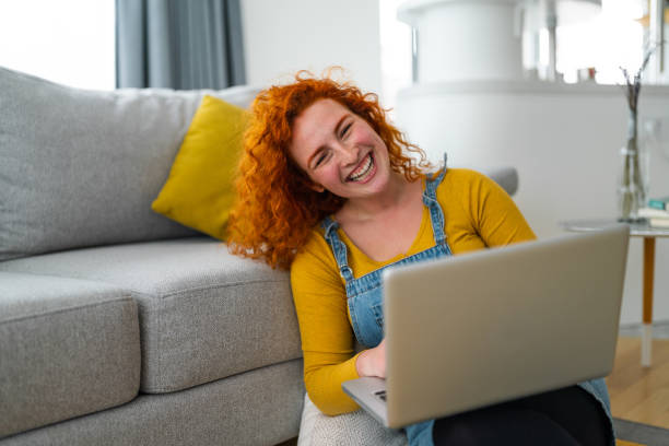 istock Independent young woman, sitting in modern decorated flat, using laptop 1949829869