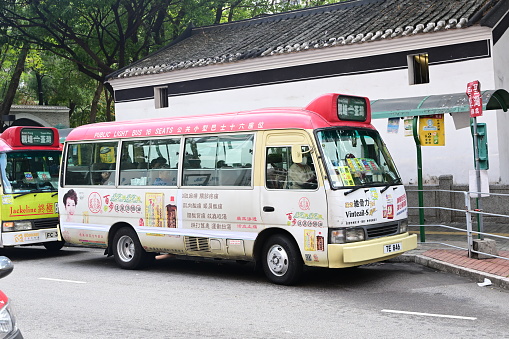 Tourist bus moves along the road along the lake shore in summer