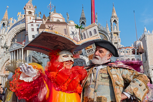 Venice, Italy - February 21, 2022: The Carnival of Venice, when visitors and residents of Venice dress up in wonderfully elaborate costumes and parade through the squares and along the banks of the canals.