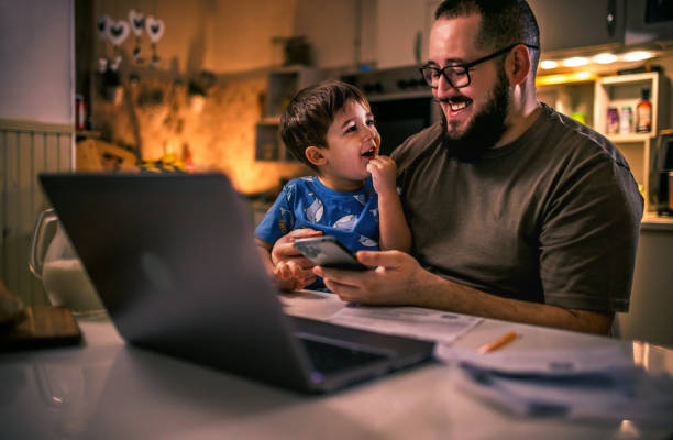 istock young dad uses laptop and pays bills while son tries to distract him 1949852097