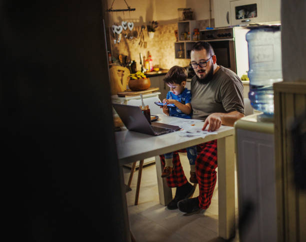 istock young dad uses laptop and pays bills while son tries to distract him 1949853694