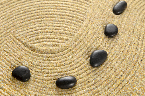 Vertical shoot of balanced pebbles on beach sand
