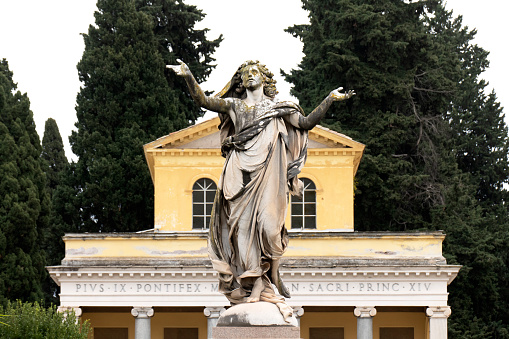Cemetery of Verano, Rome, Italy: the statue of Redeemer by Leopoldo Ansiglioni in 1887. In the background, the church of Saint Mary of Mercy.