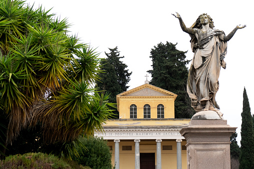 Cemetery of Verano, Rome, Italy: the statue of Redeemer by Leopoldo Ansiglioni in 1887. In the background, the church of Saint Mary of Mercy.