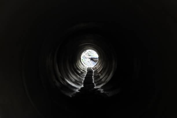 istock View through a round concrete tunnel carrying a stream beneath a road 1949933242