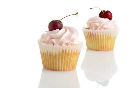 closeup of cherry buttercream cupcakes on white