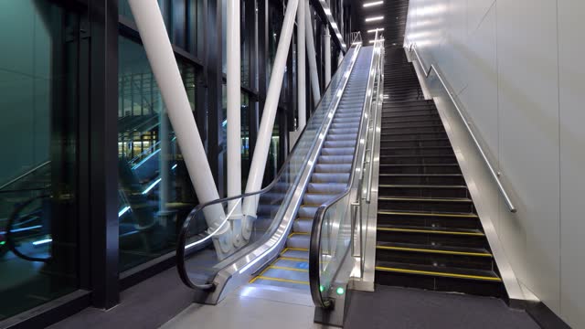Escalator and stairs leading upward, arrival area of international airport