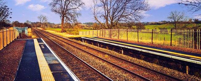 A station England UK. Diesel powered railway line in the English countryside. Station on a sunny day. Panoramic - Panorama.