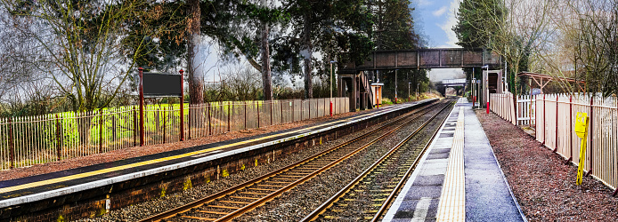 A station England UK. Diesel powered railway line in the English countryside. Station on a sunny day. Panoramic - Panorama.