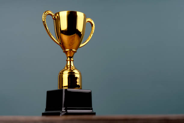 istock Gold trophy on green background with copy space 1950017530