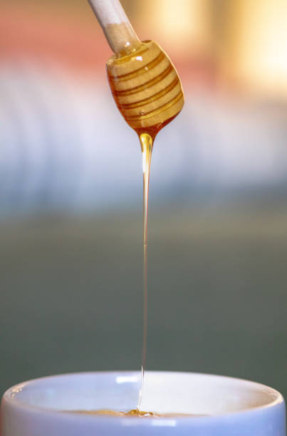 Glistening honey cascading into a steaming cup of coffee