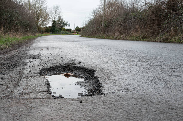 istock Deep road pothole filled with rainwater. 1950068917