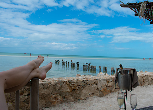 Champagne on the beach with blue skies in Holbox Mexico.