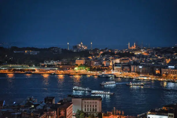 Panoramic night view of the lit up Hagia Sophia and Blue mosque against the night skyline of historic Istanbul, Turkey