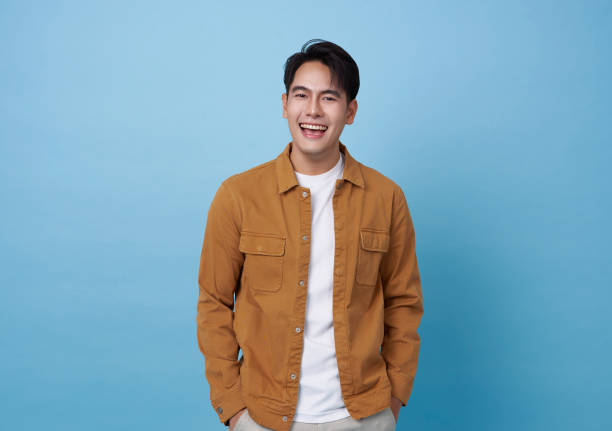 istock Happy laughing young handsome southeast Asian man isolated on blue studio background. 1950110306