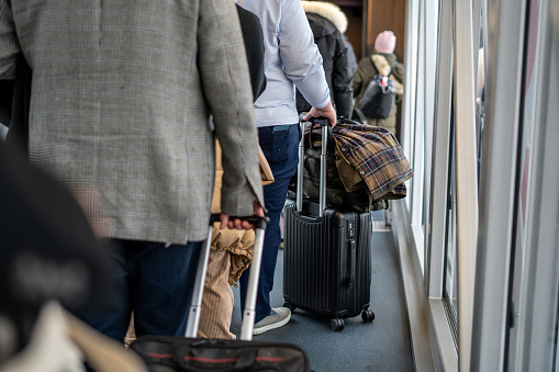 people with suitcases are waiting to airplane at airport horizontal travel still