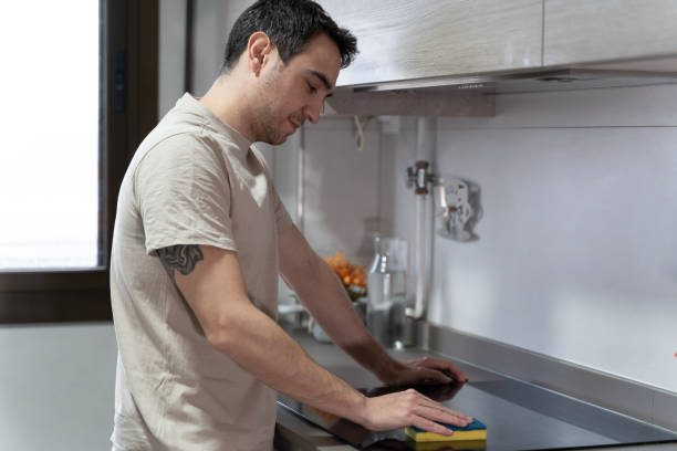 istock Man Cleaning Kitchen Counter With Sponge, Hygiene and Housekeeping 1950146482