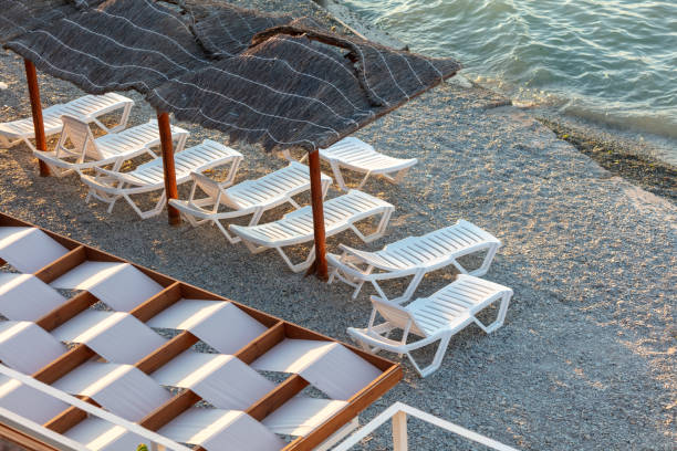istock Empty sunbeds on a pebble beach at sunset 1950151712