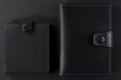Black leather wallet on a black background.