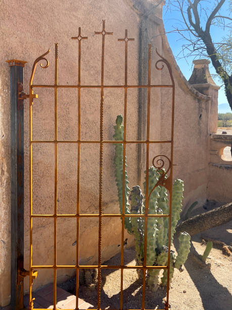 Tucson, AZ, USA - January 18, 2024: Metal gate at the entrance to the pathway around the San Xavier del bac Mission in Tucson, AZ Tucson, AZ, USA - January 18, 2024: Metal gate at the entrance to the pathway around the San Xavier del bac Mission in Tucson, AZ tohono o'odham stock pictures, royalty-free photos & images