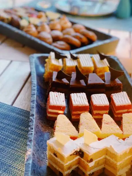 A table with a tray of desserts and plates of food