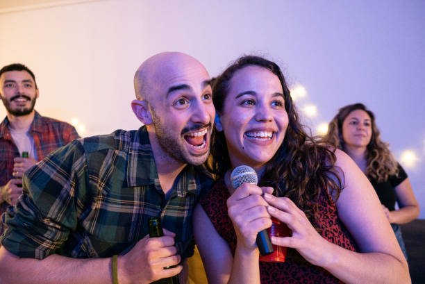 istock Friends having fun singing karaoke during a party at home 1950191668