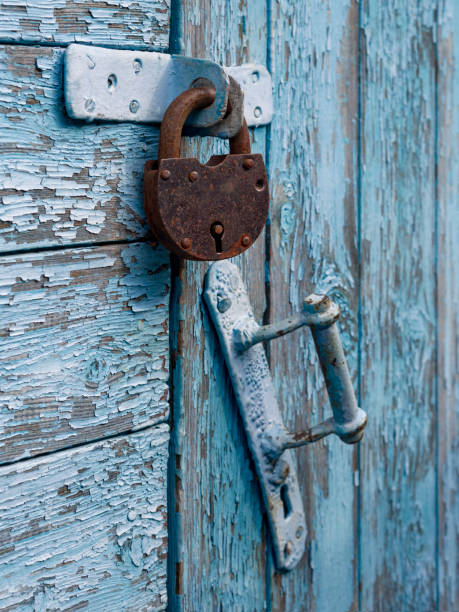 istock Locked old red double door with rusty padlock. Peeled door 1950197971