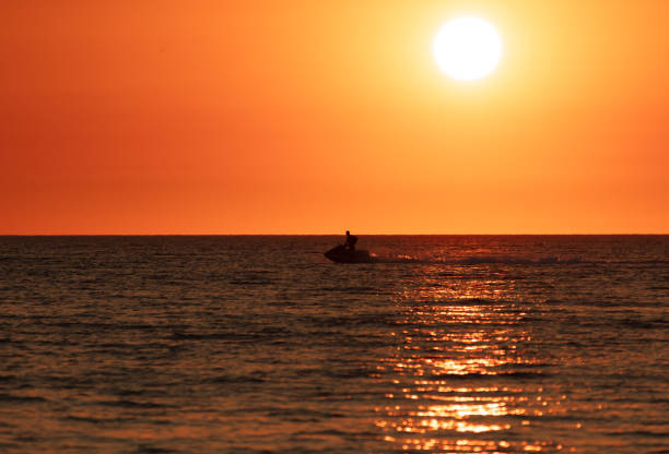 istock A man on a water scooter rides along the sea. sunset 1950200600