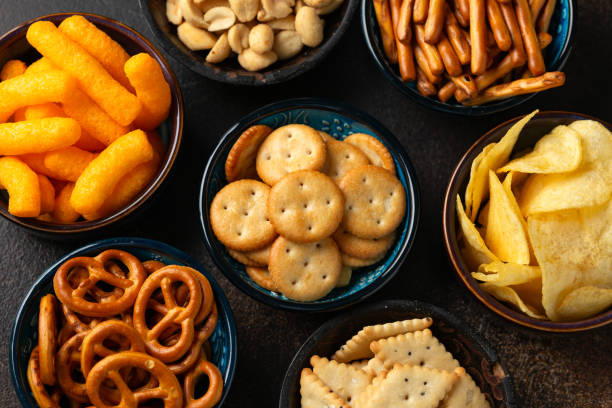 istock Salty snacks crackers, potato chips, pretzel, peanuts, corn puffs. 1950216021