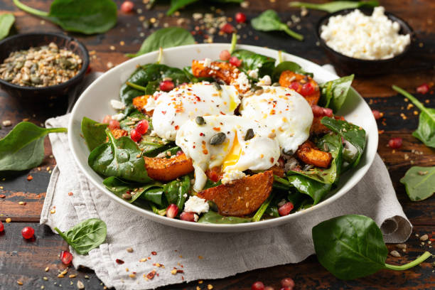 istock Roasted butternut squash salad served with poached eggs, spinach, nuts and pomegranate seeds 1950216555