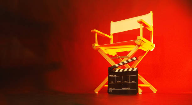 istock Director chair and black clapper board in red light. 1950219192