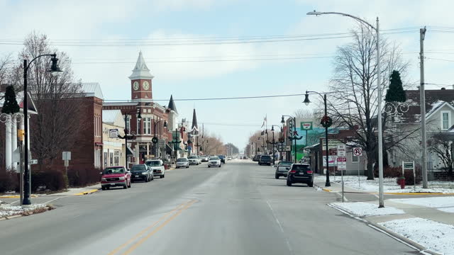 Car Point of View Shot of Driving Down E 1st Passing Businesses in Sumner, IA after a Snowstorm on a Sunny Day