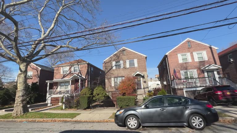 Driving Side View of Closely Built Brick Homes in East Bronx, New York on a Clear, Sunny Day