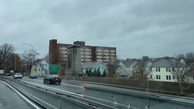 Car Point of View from a Highway Looking Across a Neighborhood of Single Family Homes and Apartment Buildings in Providence, Rhode Island on an Overcast Day