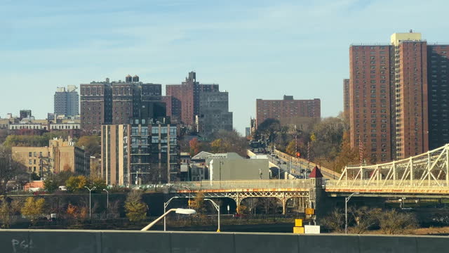 Driving Side Point of View Shot From I-87 (Interstate 87) Bruckner Blvd with Large Buildings and Macombs Dam Bridge in South Bronx, New York on a Sunny Day