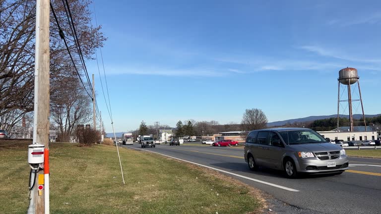 Trucks and Other Traffic Passing by on a Busy Blue Ridge Mountains Road in Harrisonburg, Virginia on a  Sunny Day with Light Clouds in the Sky