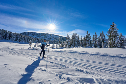 nice and active senior woman cross-country skiing in the Hochhaedrich area of Bregenz Forest in Vorarlberg, Austria